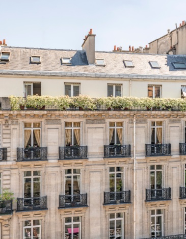 Façade d’immeuble haussmannien avec balcons en fer forgé et fenêtres élégantes
