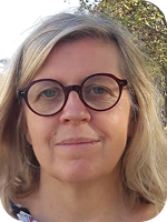 Portrait d’une femme souriante portant des lunettes dans un environnement extérieur naturel